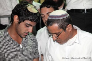 Ouria Yifrah, father of missing teenager Eyal Yifrah, and Eyal's brother Assaf, pray alongside hundreds for the safety of Eyal, June 14, 2014. 